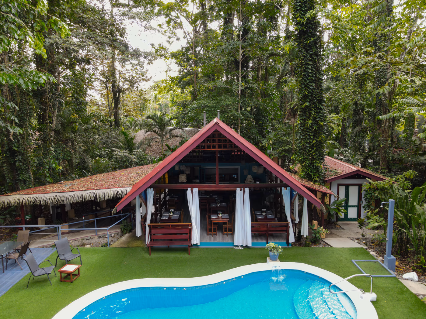 Aerial view of the pool and open-air restaurant nested in tropical gardens