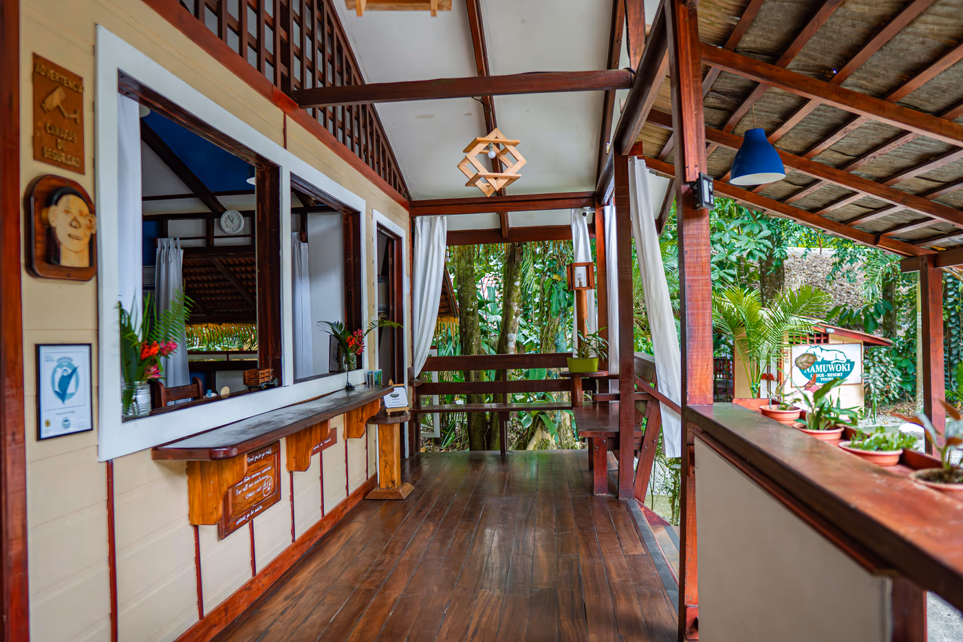 The reception interior with its wooden counter, open on both sides to the jungle