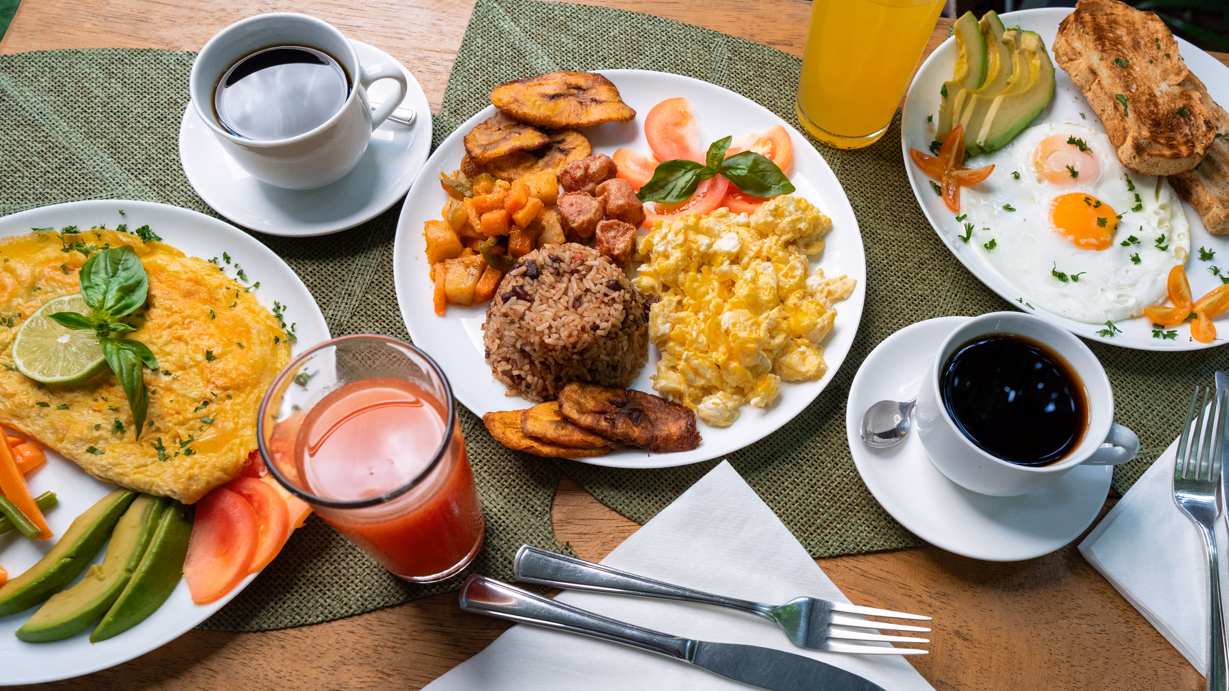Desayuno tradicional de gallo pinto con plátano, huevos revueltos y jugo natural