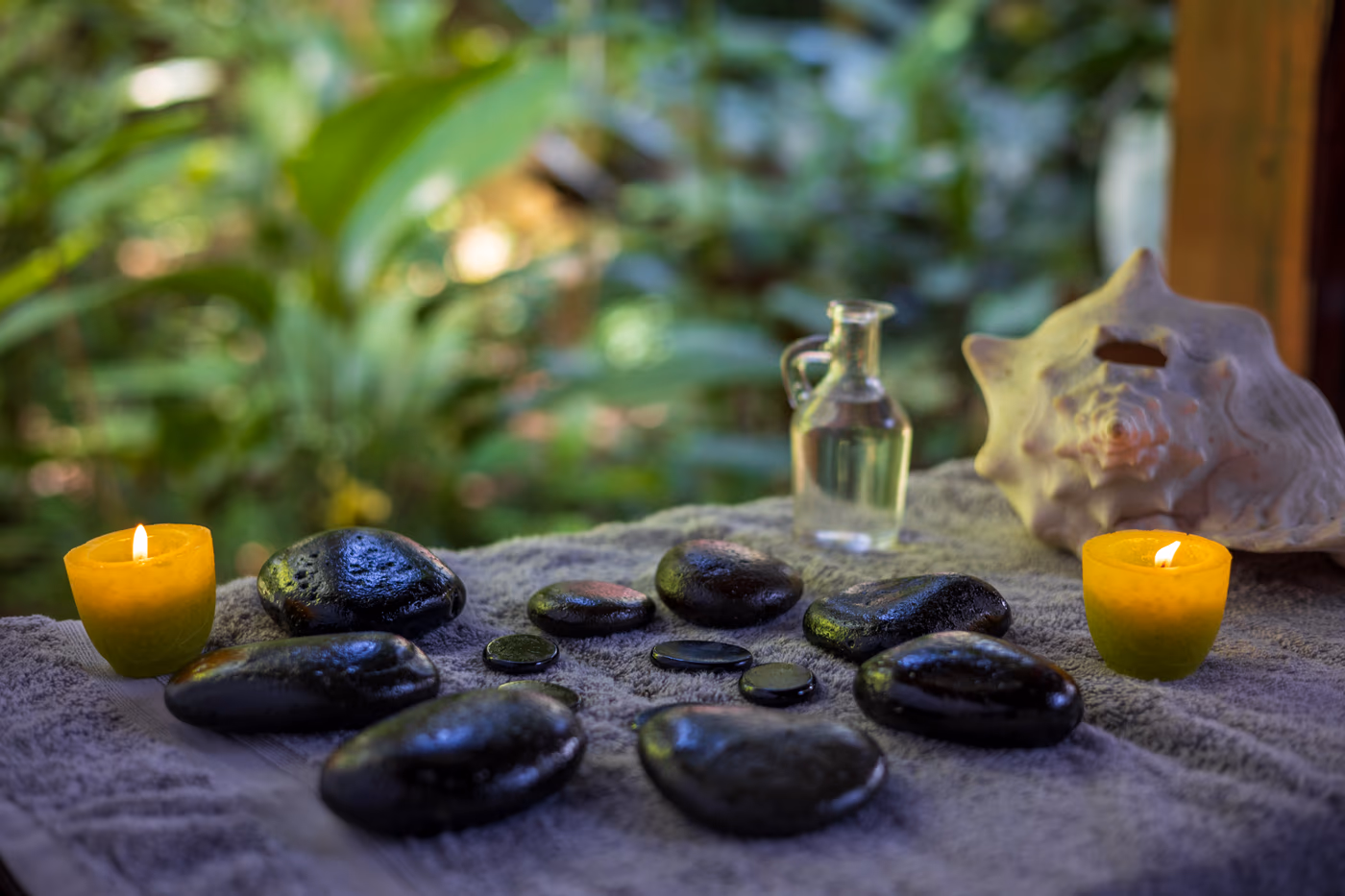 Hot stones, candles and seashell arranged in the Caribbean rainforest at Spa Namuwoki